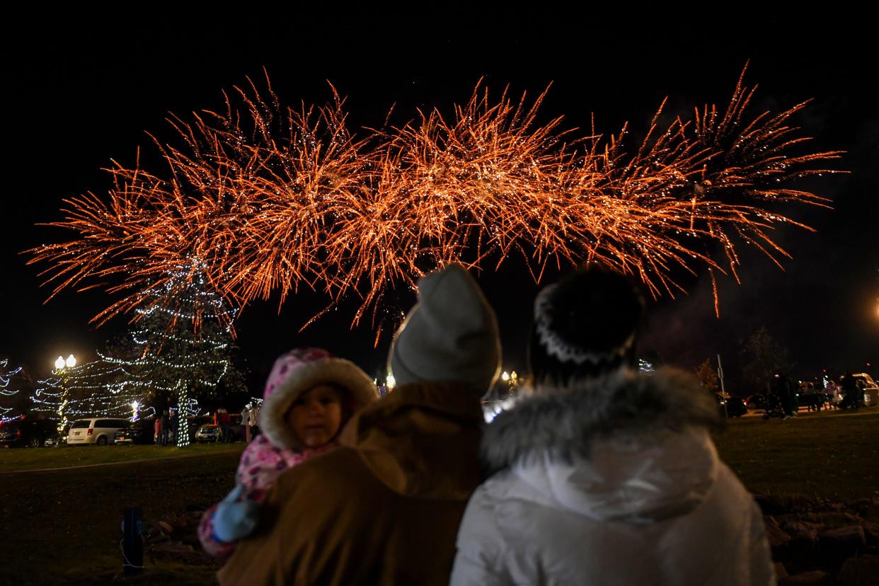 (Left to right) Yuna, Brett and Beth K. watch the fireworks together on the first night of Falls Park holiday light display on Friday, Nov. 17, 2023 in Sioux Falls.