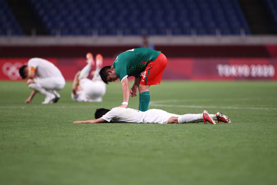 SAITAMA, JAPAN - AUGUST 06: Takefusa Kubo #7 of Team Japan looks dejected as he is consoled by Jesus Angulo #4 of Team Mexico following defeat in the Men's Bronze Medal Match between Mexico and Japan on day fourteen of the Tokyo 2020 Olympic Games at Saitama Stadium on August 06, 2021 in Saitama, Tokyo, Japan. (Photo by Koki Nagahama/Getty Images)