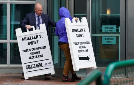 Workers take in signs from outside Denver Federal Court where the Taylor Swift groping trial jury selection begins in Denver, U.S., August 7, 2017. REUTERS/Rick Wilking