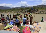 Colombianos cargan sus pertenencias a través del río Táchira. REUTERS/Jose Miguel Gomez