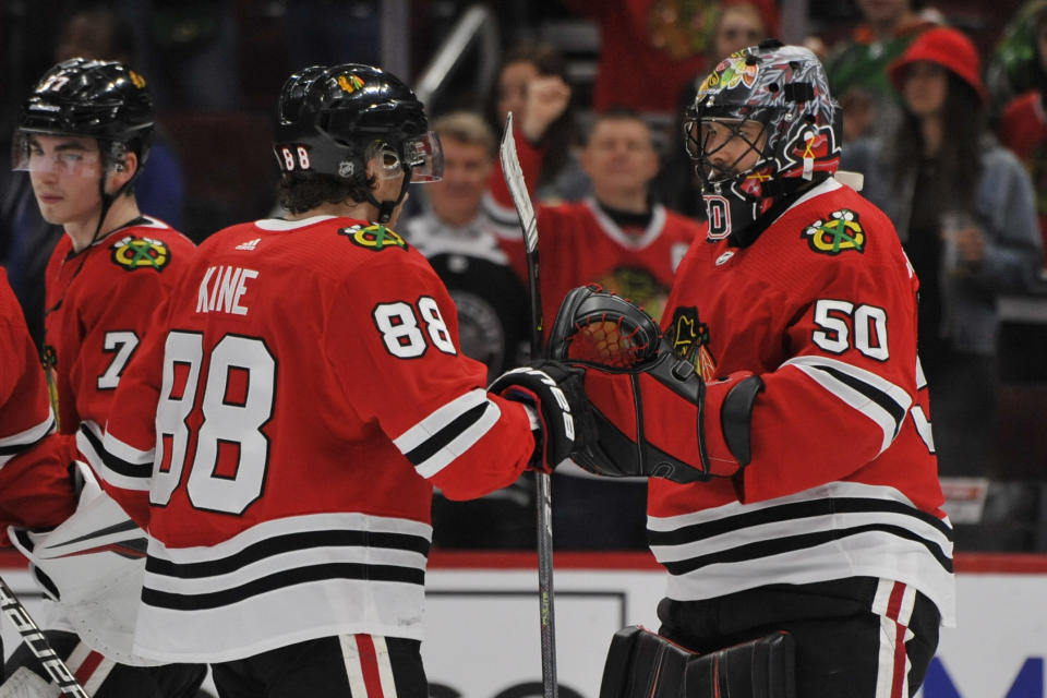 Chicago Blackhawks goalie Corey Crawford (50) celebrates with Patrick Kane (88) after the Blackhawks defeated the San Jose Sharks 6-2 in an NHL hockey game Wednesday, March 11, 2020, in Chicago. (AP Photo/Paul Beaty)