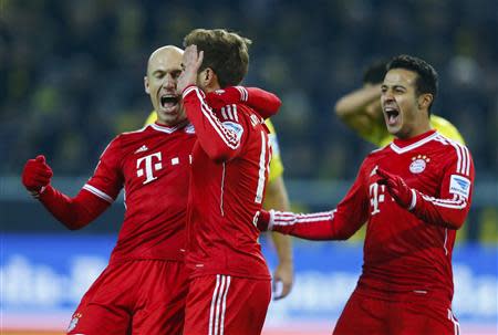 Bayern Munich's Mario Goetze (C) celebrates with team mates Arjen Robben and Thiago (R) after he scored a goal against Borussia Dortmund during their German first division Bundesliga soccer match in Dortmund, November 23, 2013. REUTERS/Kai Pfaffenbach