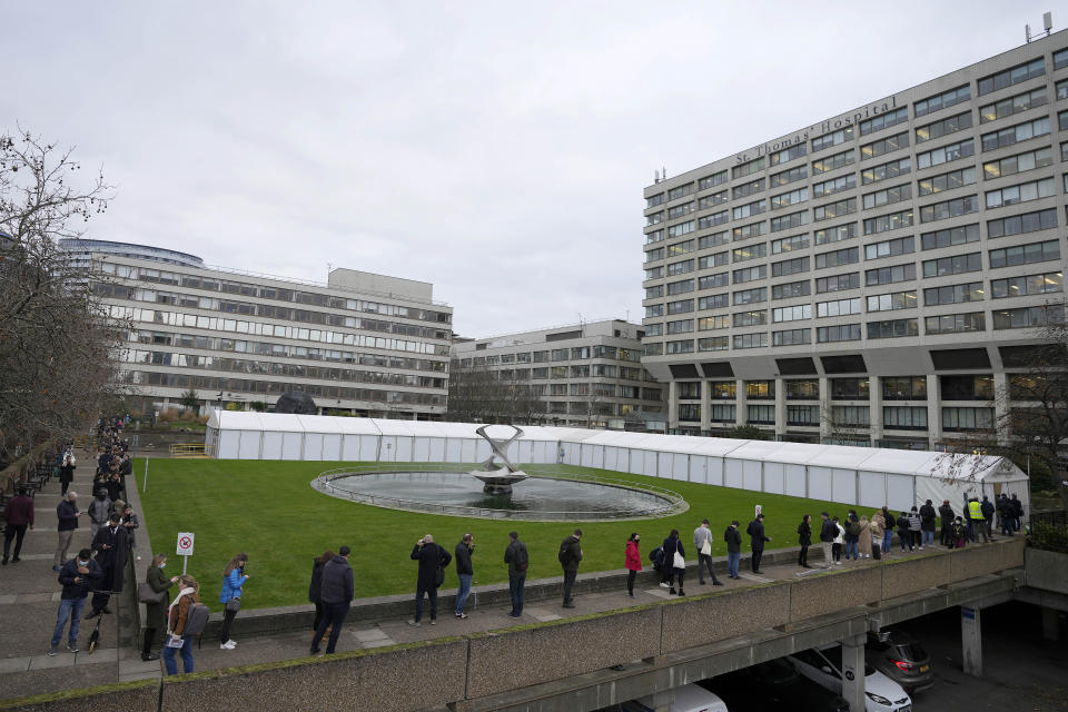 People queue for their vaccination at St Thomas' Hospital in London, Wednesday, Dec. 15, 2021. Long lines have formed for booster shots across England as the U.K. government urged all adults to protect themselves against the omicron variant. (AP Photo/Frank Augstein)