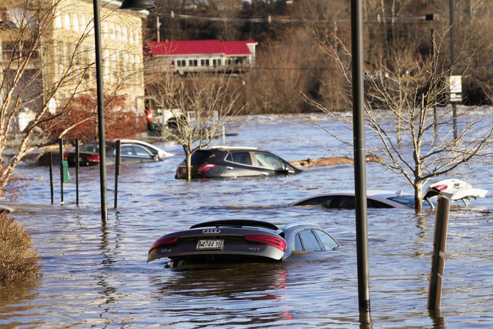 Cars are flooded in a parking lot at the Hathaway Creative Center alongside the Kennebec River, Tuesday, Dec. 19, 2023, in Waterville, Maine. A severe storm on Monday flooded rivers and knocked out power to hundreds of thousands. (AP Photo/Robert F. Bukaty)