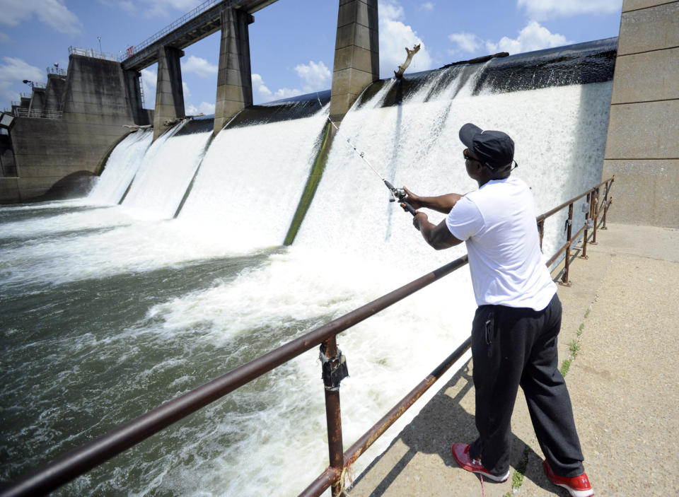 In this Tuesday, July 9, 2019 photo, Brad Shaw fishes at the Heflin Lock and Dam along the Tennessee-Tombigbee Waterway in Epes, Ala. While the waterway hasn't fulfilled promises of stoking economic development in Alabama and Mississippi or met barge traffic projections, the 234-mile-long stream is a haven for anglers and boaters. (AP Photo/Jay Reeves)
