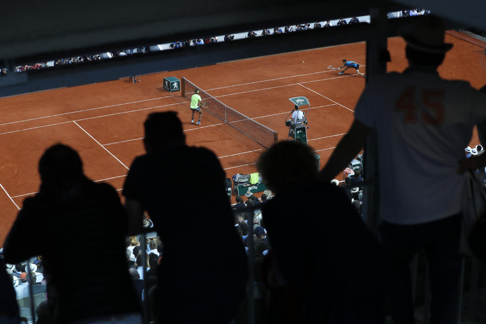 Espectadores observan a Rafael Nadal (izquierda) y Dominic Thiem disputar la final del Abierto de Francia en París, el domingo 9 de junio de 2019. (AP Foto/Pavel Golovkin)