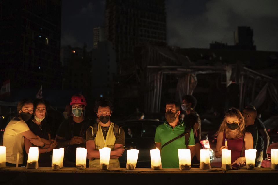 Demonstrators light candles honoring the victims of the deadly explosion at Beirut port which devastated large parts of the capital, in Beirut, Lebanon, Sunday, Aug. 9, 2020. (AP Photo/Felipe Dana)