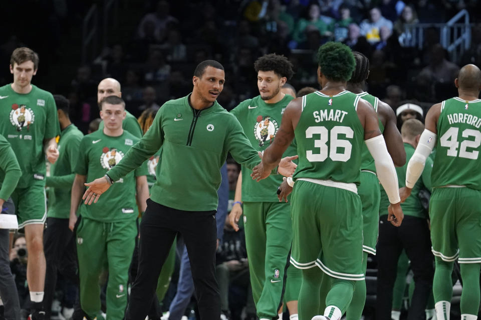 Boston Celtics interim head coach Joe Mazzulla, center, celebrates with guard Marcus Smart (36) after their team scored in the second half of an NBA basketball game against the Golden State Warriors, Thursday, Jan. 19, 2023, in Boston. (AP Photo/Steven Senne)