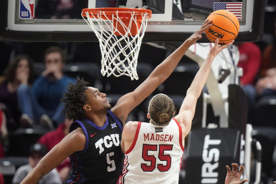 TCU forward Chuck O'Bannon Jr. (5) defends against Utah guard Gabe Madsen (55) during the first half of an NCAA college basketball game Wednesday, Dec. 21, 2022, in Salt Lake City. (AP Photo/Rick Bowmer)