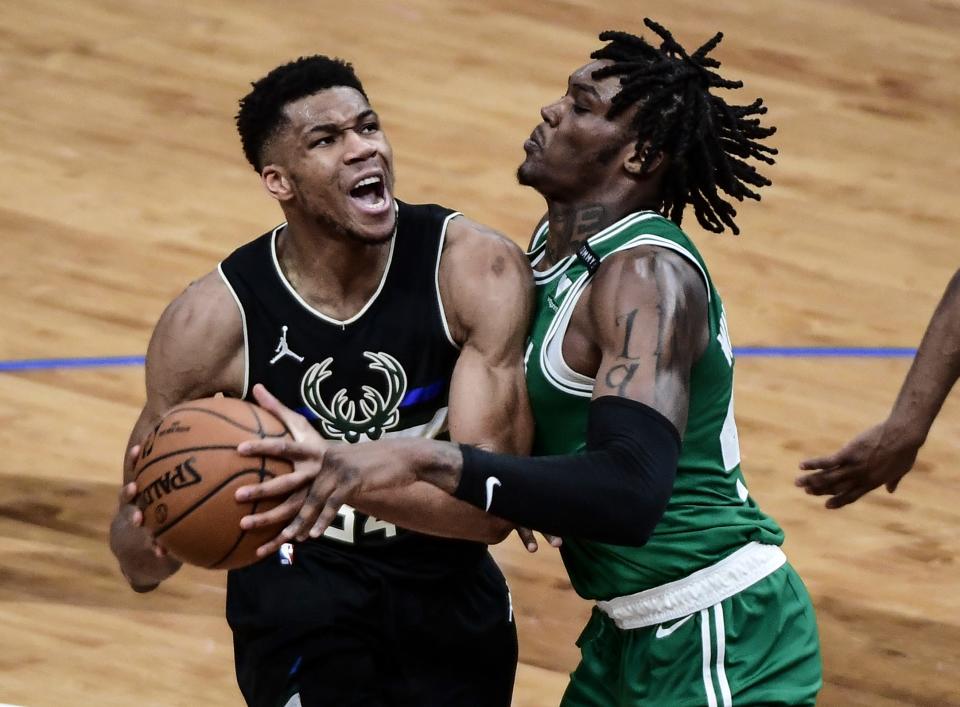 Bucks forward Giannis Antetokounmpo looks for a shot as Celtics center Robert Williams III provides tight defense.