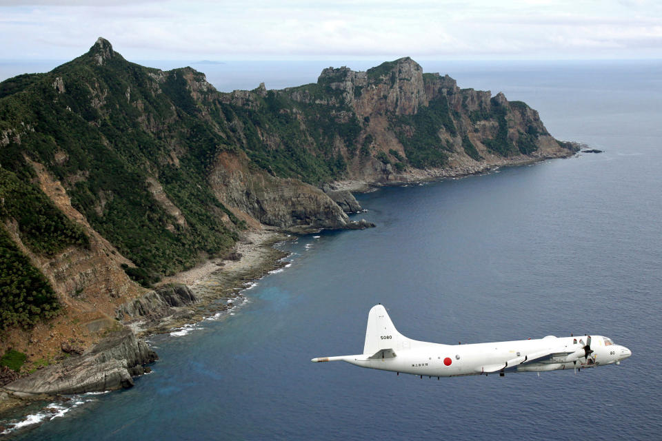 FILE - In this Oct. 13, 2011, file photo, Japan Maritime Self-Defense Force P-3C Orion surveillance plane flies over the disputed islands, called the Senkaku in Japan and Diaoyu in China, in the East China Sea. The Abe government's Defense White Paper 2020 highlights what are potential Chinese and North Korean threats as Japan tries to further increase its defense capability. (Kyodo News via AP, File)