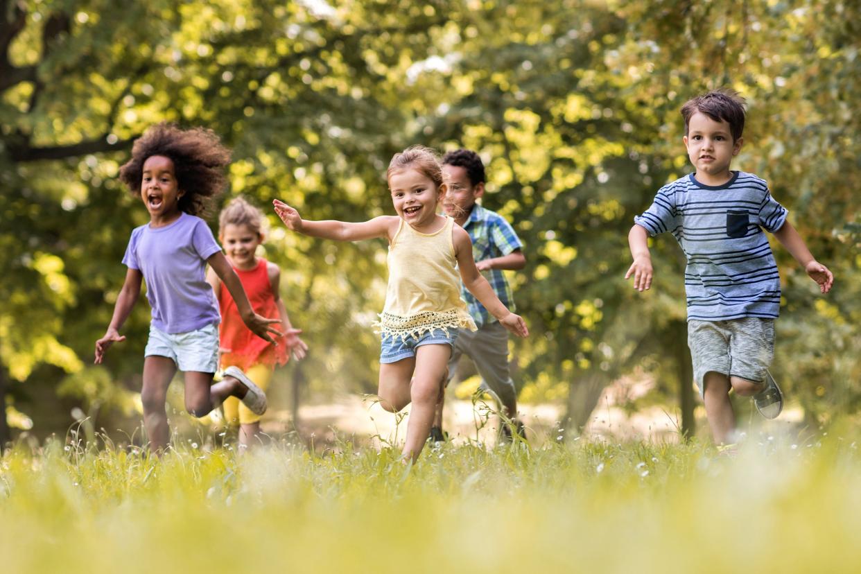 group of happy children having fun while running in nature