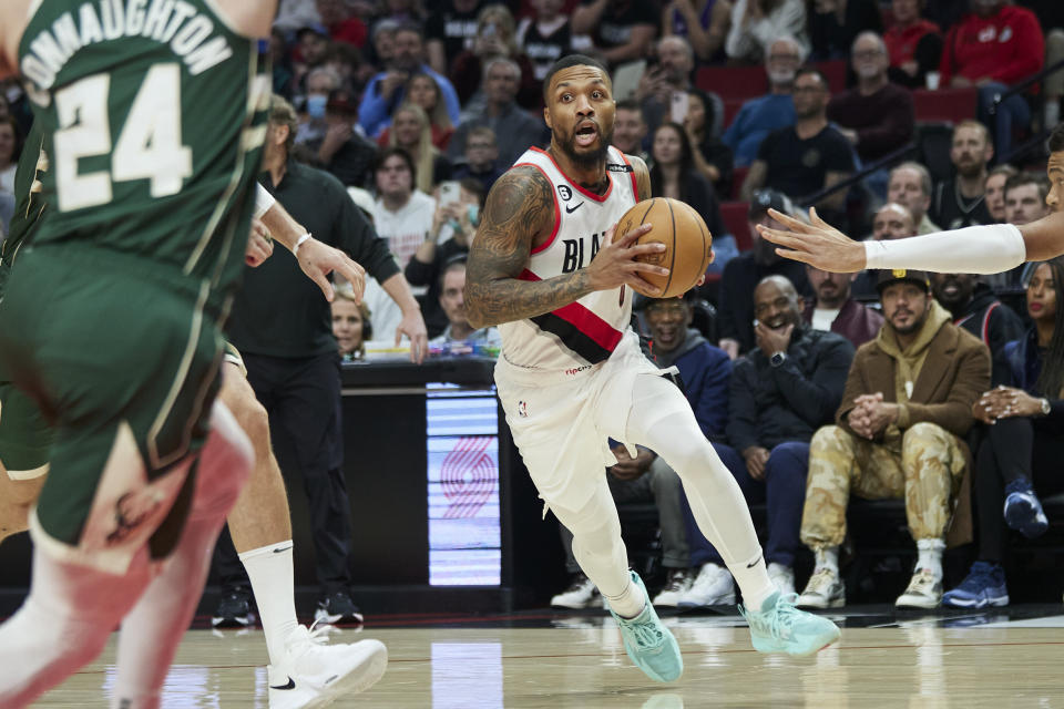 Portland Trail Blazers guard Damian Lillard, center, drives to the basket against the Milwaukee Bucks during the first half of an NBA basketball game in Portland, Ore., Monday, Feb. 6, 2023. (AP Photo/Craig Mitchelldyer)