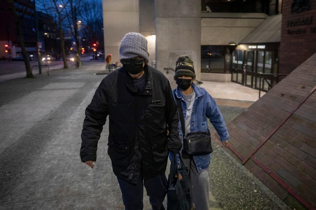 Kemthong Clasby, right, and Terence Lee Clasby are pictured leaving provincial court on Jan. 16, 2024 after Kemthong was fined $3,500 for leaving food in Vancouver's Stanley Park in 2021 that could have attracted dangerous animals such as coyotes.  (Ben Nelms/CBC News - image credit)