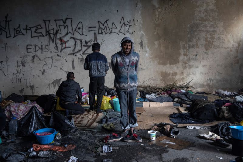 Migrants from Bangladesh stand inside an old abandoned factory near Velika Kladusa