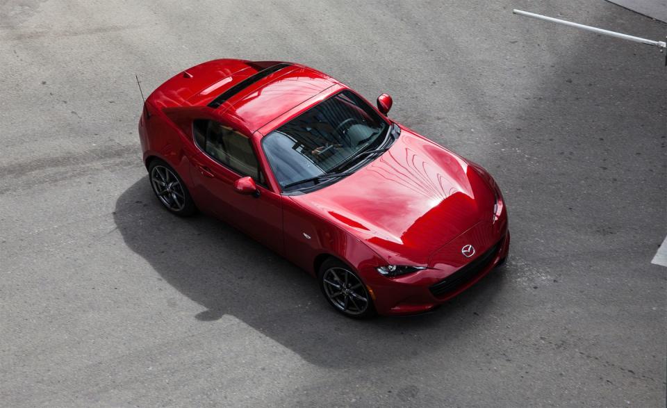 <p>Mazda debuts the Power Retractable Hardtop model's spiritual successor for 2017: the MX-5 Miata RF. Short for "Retractable Fastback," the RF resembles a Miata coupe but is really a power-operated targa-either way, it's gorgeous. At the press of a button on the console, the roof panel immediately above the passenger compartment flips up and retracts into a well beneath the rear deck. This dance requires the pair of roof buttresses stretching to the rear quarter-panels to lift up and back, a mesmerizing sequence. With the roof raised, the Miata is somewhat quieter inside than the softtop models and does a convincing impression of a fixed-roof coupe. </p>