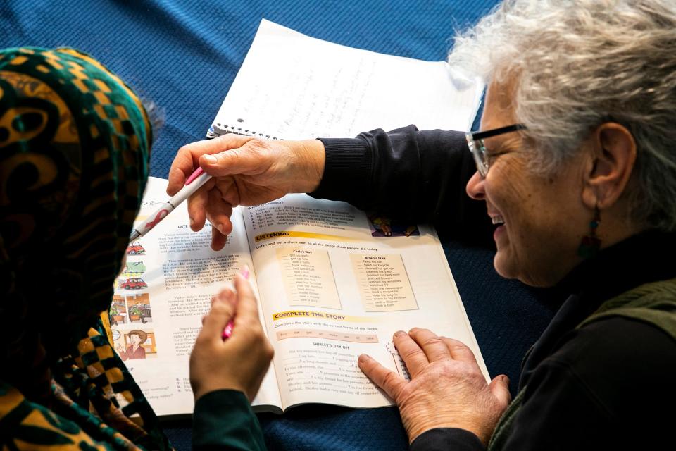 Peg Bouska, right, goes over an English lesson with Rukhsar Azizi at her home in Iowa City.