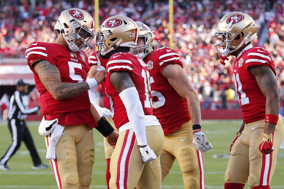 San Francisco 49ers quarterback Trey Lance, left, celebrates after throwing a touchdown pass to Deebo Samuel, middle, during the second half of an NFL football game against the Houston Texans in Santa Clara, Calif., Sunday, Jan. 2, 2022. (AP Photo/John Hefti)