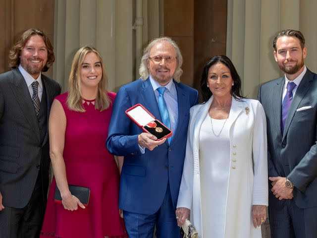 <p>Steve Parsons - WPA Pool/Getty</p> Barry Gibb with his wife, Linda and children, Michael, Alexandra and Ashley at Buckingham Palace, London, after he was knighted by the Prince of Wales at Buckingham Palace on June 26, 2018