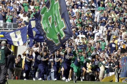 In this Sept. 8, 2012 photo, a Notre Dame mascot and cheerleaders helps lead the team on to field before an NCAA college football game against Purdue in South Bend, Ind. Ahead of the 2014 college football season, the AP asked its panel of Top 25 voters, who are known for ranking the nation&#39;s top teams each week, to weigh in on which stadium had the best game day atmosphere. Notre Dame Stadium has its Touchdown Jesus, looming over one end zone and recognition from the panel. (AP Photo/Michael Conroy, File)