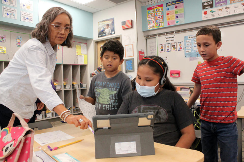 Teacher Arleen Franklin explains a math lesson to her students at Judy Nelson Elementary School on Sept. 21, 2022, in Kirkland, N.M. The closure of the nearby San Juan Generating Station and an adjacent mine is resulting in the loss of hundreds of jobs and tax revenue for the Central Consolidated School District, which serves mostly Native American students. (AP Photo/Susan Montoya Bryan)