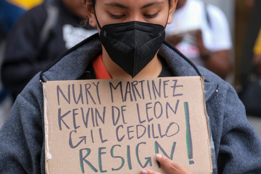 A protester holding a sign protest outside City Hall during the Los Angeles City Council meeting Tuesday, Oct. 11, 2022, in Los Angeles. (AP Photo/Ringo H.W. Chiu)