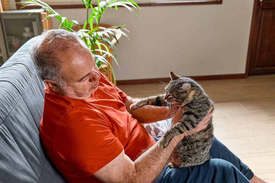 a man holding a cat in front of him