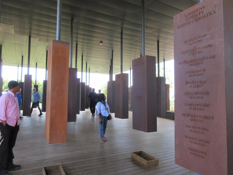People looking through signs in The National Memorial for Peace and Justice, in Montgomery, Alabama,