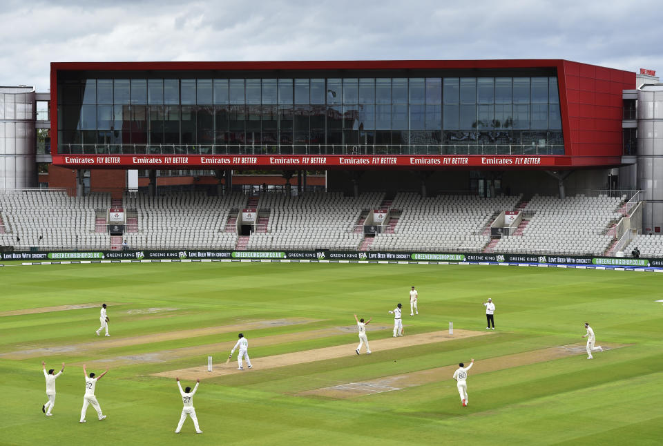 England's Chris Woakes, center right, celebrates the dismissal of Pakistan's captain Azhar Ali, center left, during the first day of the first cricket Test match between England and Pakistan at Old Trafford in Manchester, England, Wednesday, Aug. 5, 2020. (Dan Mullan/Pool via AP)