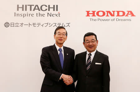 Honda Chief Executive Officer Takahiro Hachigo (R) and his Hitachi Automotive counterpart Hideaki Seki shake hands at a photo session after their news conference in Tokyo, Japan, February 7, 2017. REUTERS/Kim Kyung-Hoon