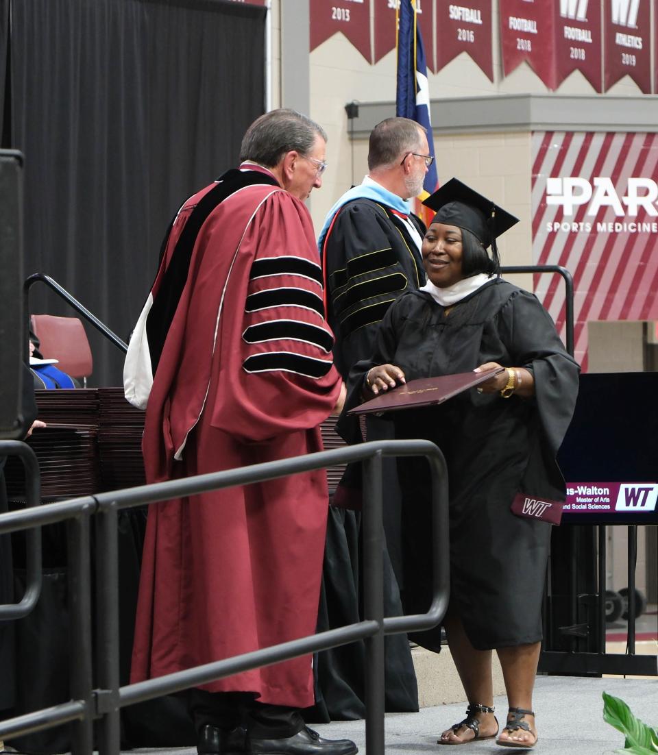 A graduate is greeted by university president Walter Wendler Saturday at the WT Commencement Ceremony in Canyon.