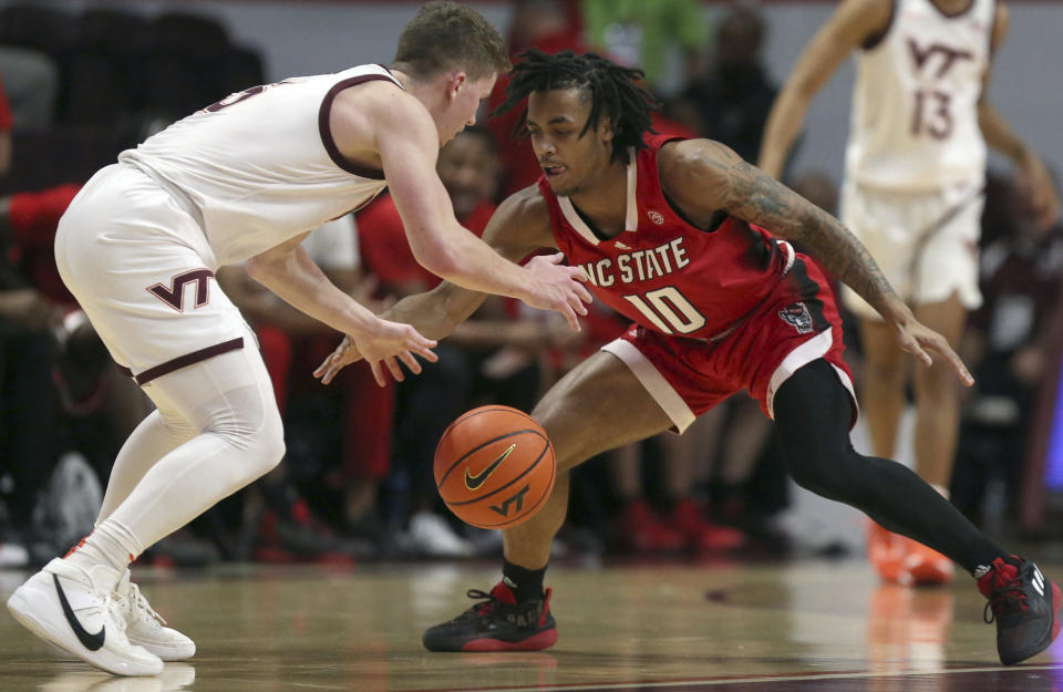 Virginia Tech's Sean Pedulla (3) and North Carolina State's Breon Pass (10) compete for a tipped ball during the first half of an NCAA college basketball game Saturday, Jan. 7, 2023, in Blacksburg, Va. (Matt Gentry/The Roanoke Times via AP)