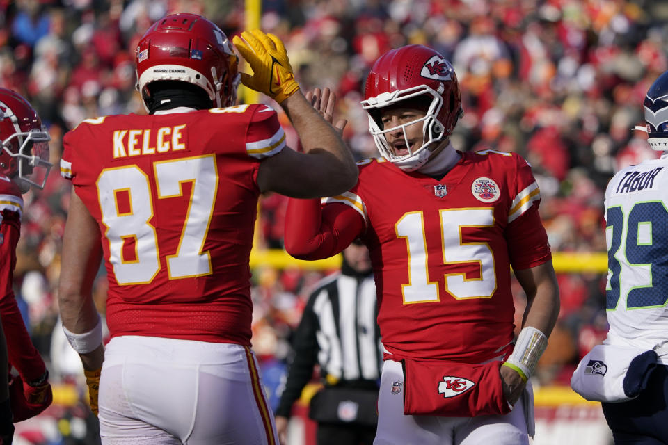 Kansas City Chiefs quarterback Patrick Mahomes (15) and tight end Travis Kelce (87) celebrate during the first half of an NFL football game against the Seattle Seahawks Saturday, Dec. 24, 2022, in Kansas City, Mo. (AP Photo/Ed Zurga)