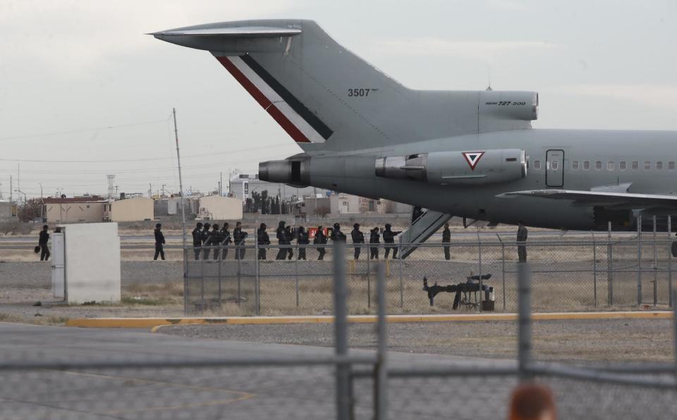 Police board Mexican Air Force plane after the extradition of drug lord Joaquin "El Chapo" Guzman in Ciudad Juarez, Mexico, Thursday, Jan. 19, 2017. Mexico's Foreign Relations Department announced Guzman was handed over to U.S. authorities for transportation to the U.S. on Thursday, the last day of President Barack Obama's administration and a day before Donald Trump is to be inaugurated. (AP Photo/Christian Torres)