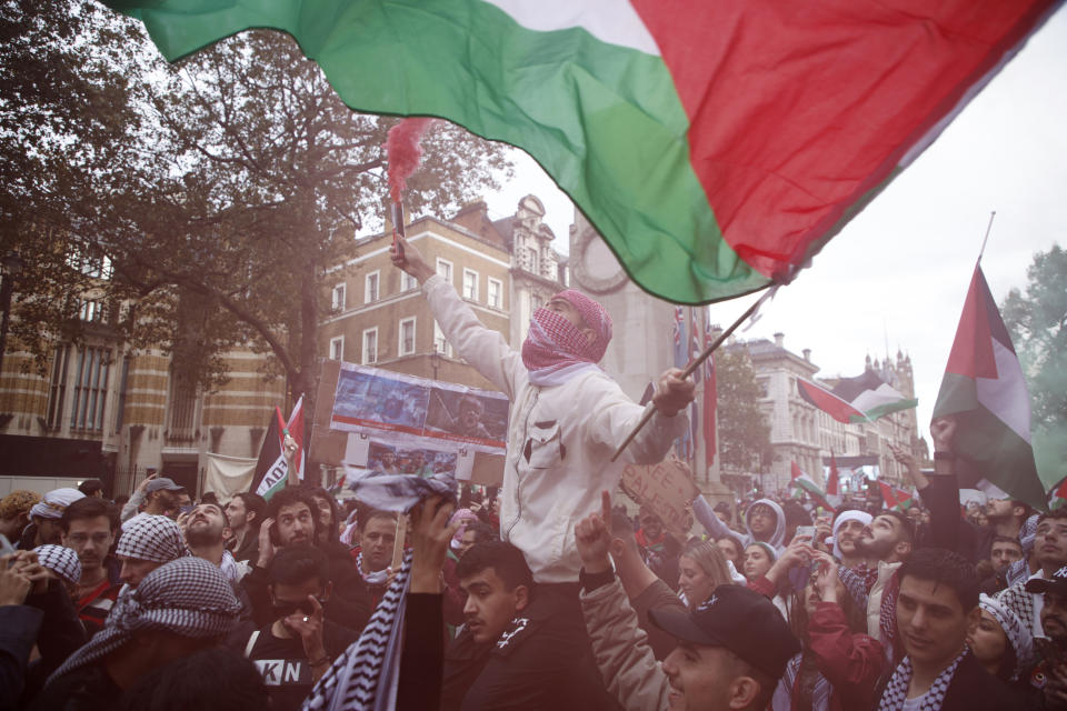 Demonstrators hold up flares, flags and placards during a pro Palestinian demonstration in London, Saturday, Oct. 21, 2023. (AP Photo/David Cliff)