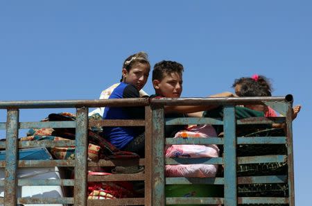 Children ride on a truck with belongings in Deraa countryside, Syria June 22, 2018. REUTERS/Alaa al-Faqir