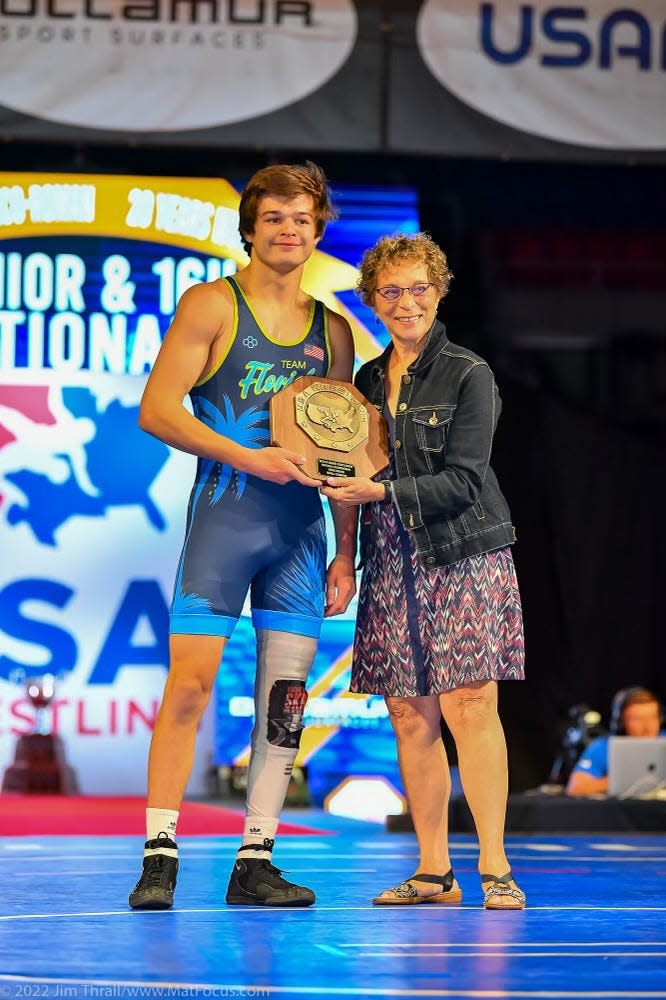 Brendon Abdon receives his award from "Voice of Wrestling" Sandy Stevens after winning the championship match in the Greco-Roman competition at 160 pounds at the 2022 US Marine Corps Junior Nationals in Fargo, N.D.