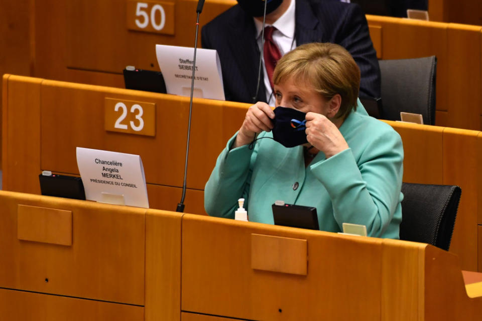 Angela Merkel, Germany's chancellor, puts on a protective face mask in the European Parliament after outlining plans for Germany's six-month presidency of the European Union, in Brussels, Belgium, on Wednesday, July 8, 2020. The German leader has stressed the grave challenges the EU faces this year, including a slumping economy, wrangling over the U.K.'s exit and the battle to tame the coronavirus pandemic. Photographer: Geert Vanden Wijngaert/Bloomberg