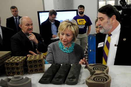 U.S. Democratic presidential candidate Hillary Clinton (C) looks at items made with a 3-D printer at Cedar Valley TechWorks in Waterloo, Iowa December 9, 2015. REUTERS/Mark Kauzlarich