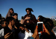 People take selfies with a Taliban in Kabul, Afghanistan June 16, 2018. REUTERS/Mohammad Ismail