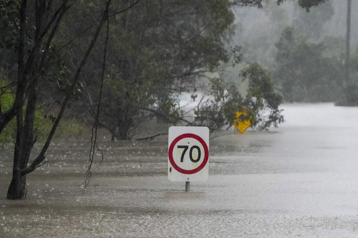 Traffic signs sit submerged along a flooded road in Londonderry on the outskirts of Sydney, Australia, Monday, July 4, 2022.
