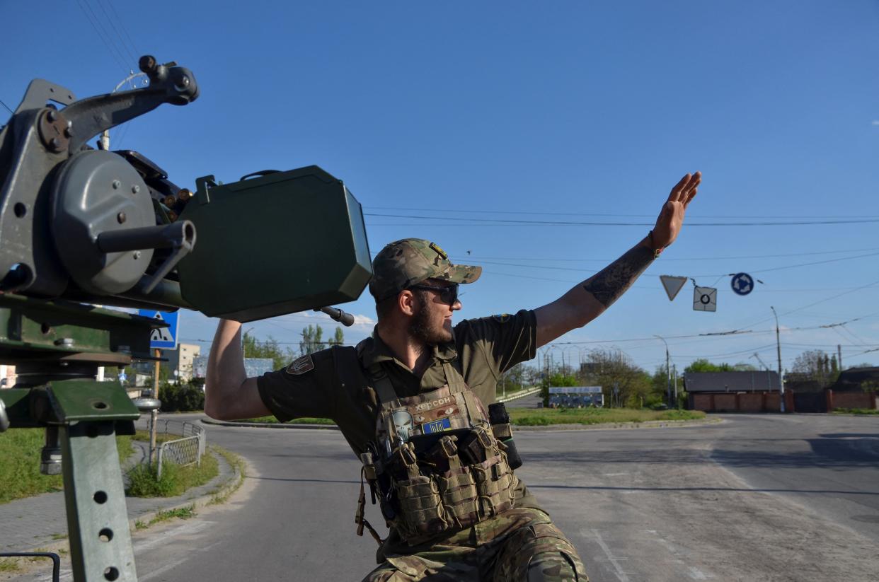 A member of the Ukrainian National Guard's mobile air defence unit waves to locals as he patrols an area (REUTERS)