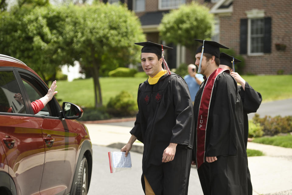 College graduates watch as friends parade by to congratulate them on Saturday, May 16, 2020. (Photo: Lauren A. Little/MediaNews Group/Reading Eagle via Getty Images)