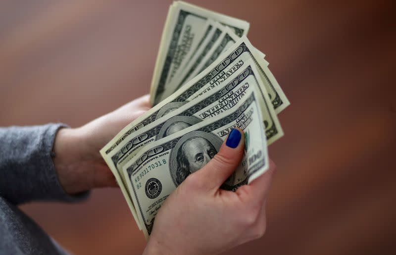 A woman counts U.S. dollar bills at her home in Buenos Aires