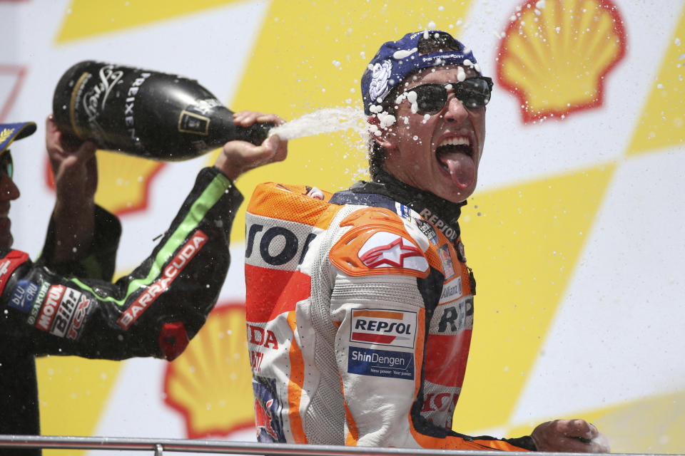 In this Sunday, Nov. 4, 2018, file photo, Honda rider Marc Marquez of Spain sprays champagne after winning the Malaysia MotoGP at the Sepang International Circuit in Sepang, Malaysia. (AP Photo/Vincent Phoon, File)