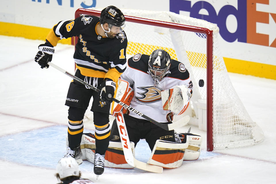 Pittsburgh Penguins' Jason Zucker (16) can't get his stick on a rebound off Anaheim Ducks goaltender John Gibson during the first period of an NHL hockey game in Pittsburgh, Saturday, Dec. 11, 2021.(AP Photo/Gene J. Puskar)