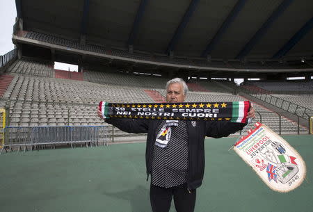 Dominico Di Bernardo, a fan of Juventus soccer team, displays a commemorative scarf and banner during a ceremony at the King Baudouin Stadium commemorating the 30th anniversary of the Heysel Stadium disaster in Brussels, Belgium May 29, 2015. REUTERS/Yves Herman