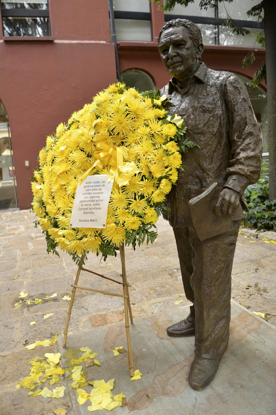 Flores adornan una estatua del Nobel de literatura Gabriel García Márquez en Bogotá, Colombia, 18 de abril de 2014. García Márquez murió a los 87 años en México el 17 de abril de 2014. El escritor era homenajeado en el Palacio de Bellas Artes de la capital mexicana, donde sus lectores y admiradores podrán acompañar sus cenizas, el lunes 21 de abril de 2014. Asistían el presidente colombiano Juan Manuel Santos y el mexicano Enrique Peña Nieto. (AP Foto/Diana Sanchez)