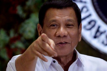 FILE PHOTO: Philippine President Rodrigo Duterte points to photographers during an awarding ceremony for outstanding government workers, at the Malacanang Palace in Manila, Philippines December 19, 2016. REUTERS/Ezra Acayan/File Photo