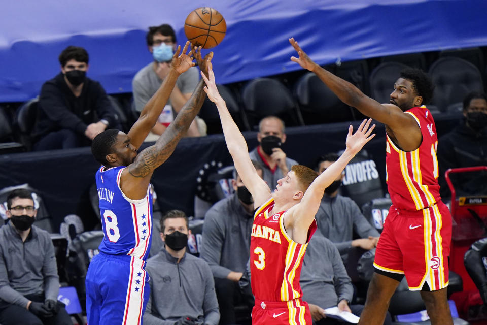 Philadelphia 76ers' Shake Milton, left, goes up for a shot against Atlanta Hawks' Kevin Huerter, center, and Solomon Hill during the second half of Game 2 in a second-round NBA basketball playoff series, Tuesday, June 8, 2021, in Philadelphia. (AP Photo/Matt Slocum)